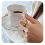 コーヒーカップを持つ女性の手元